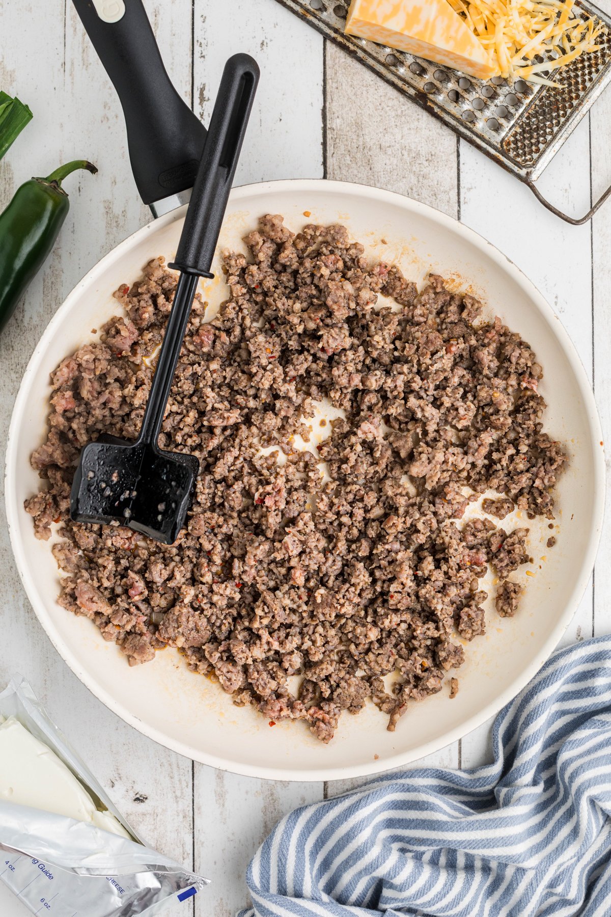 sausage dip in a skillet being browned.