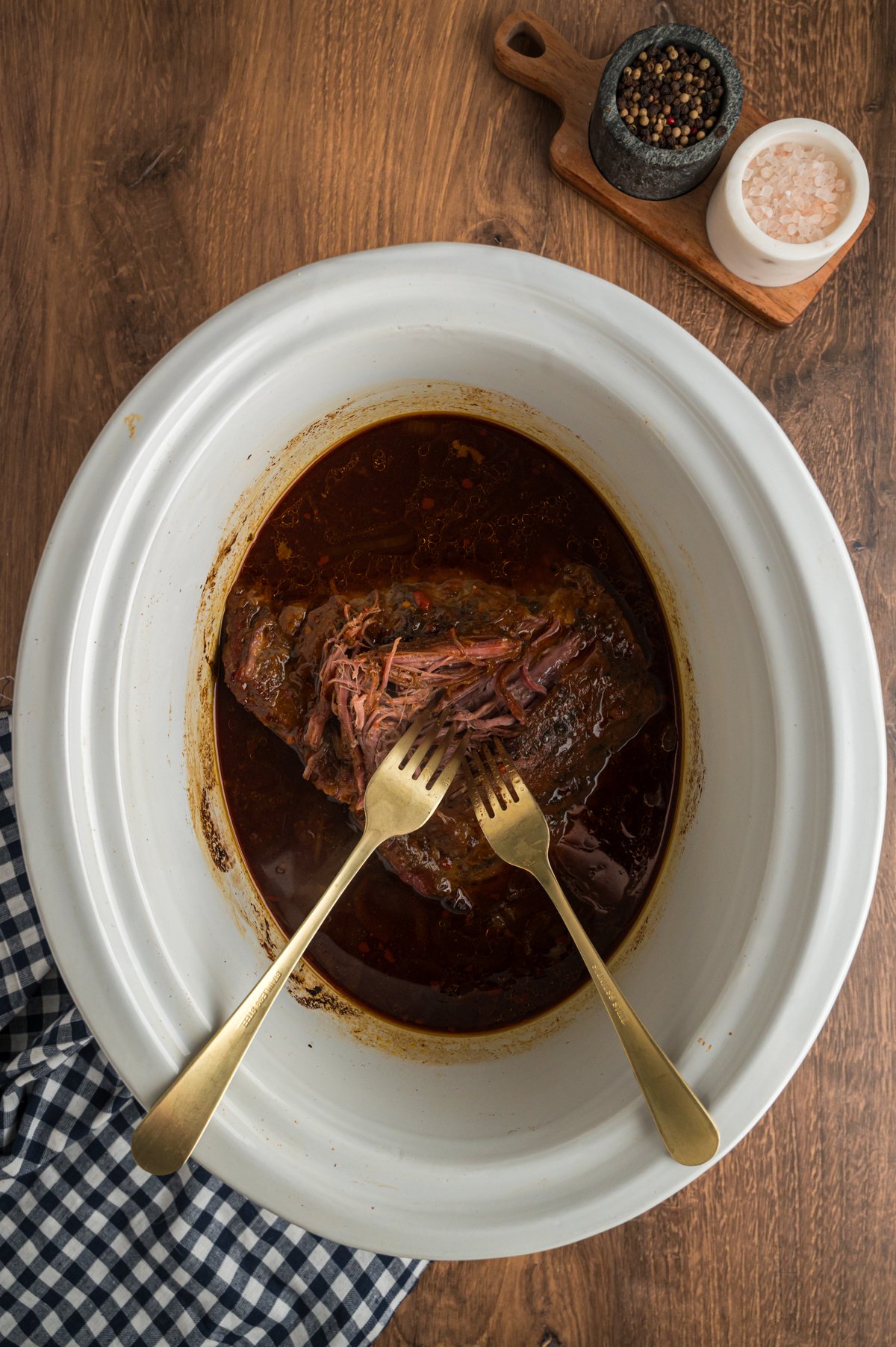 2 forks shredding flank steak.