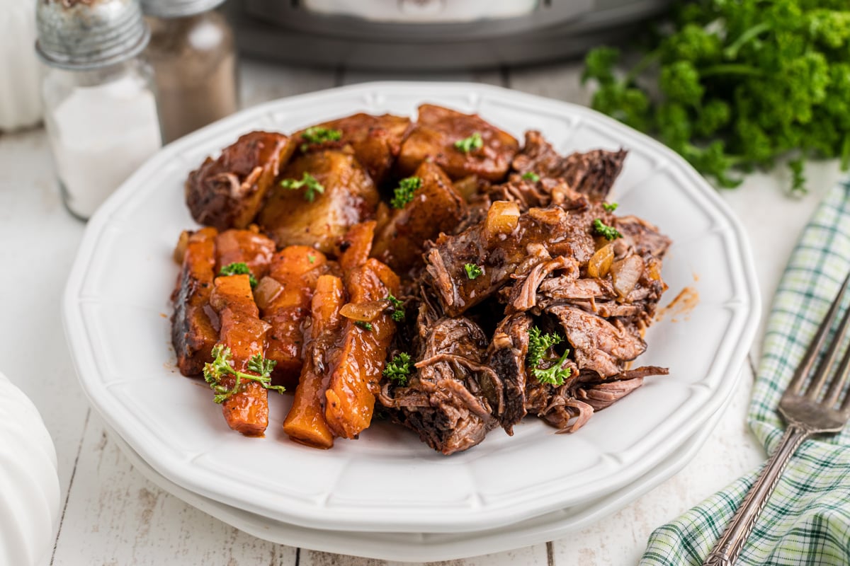 serving of slow cooker italian beef dinner on a stack of plates.