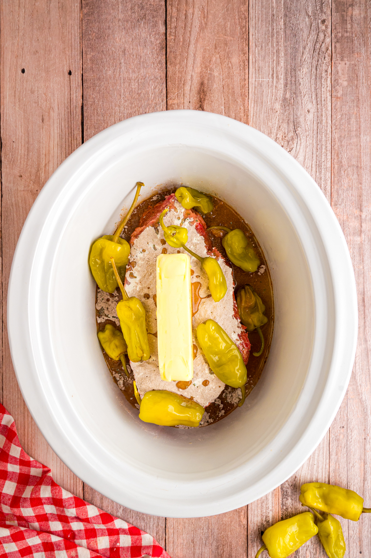 Butter and pepperoncinis added on top of roast in slow cooker.
