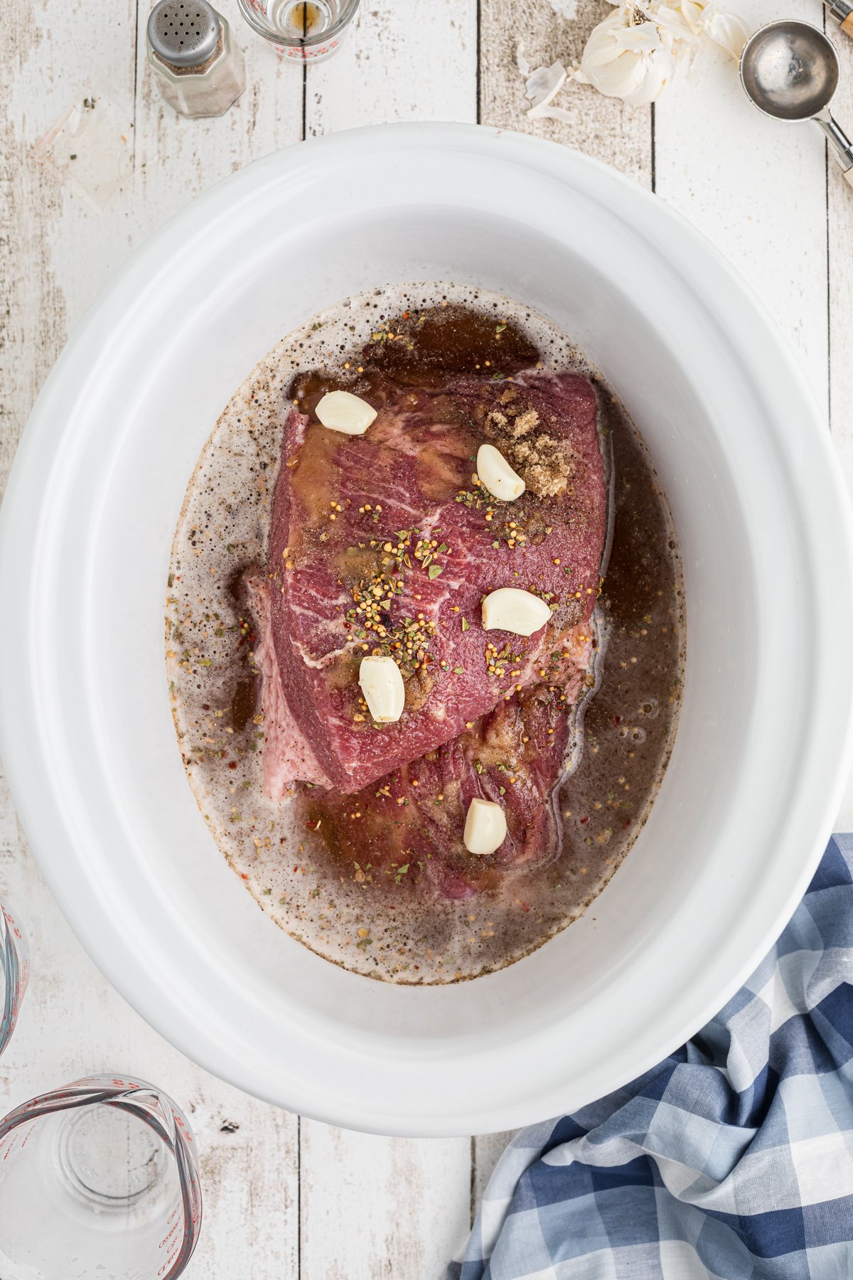 Beer poured over corned beef in slow cooker.