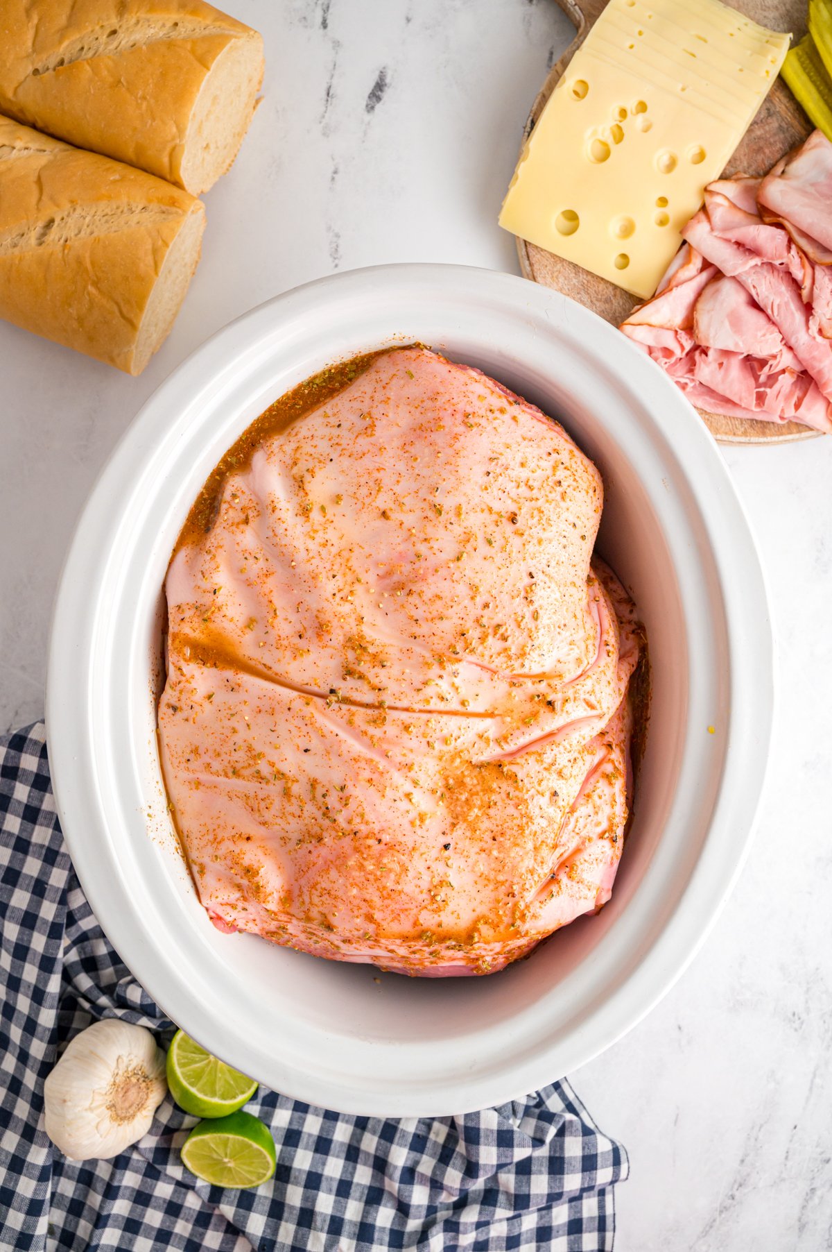 Pork shoulder and seasoning in a crockpot.