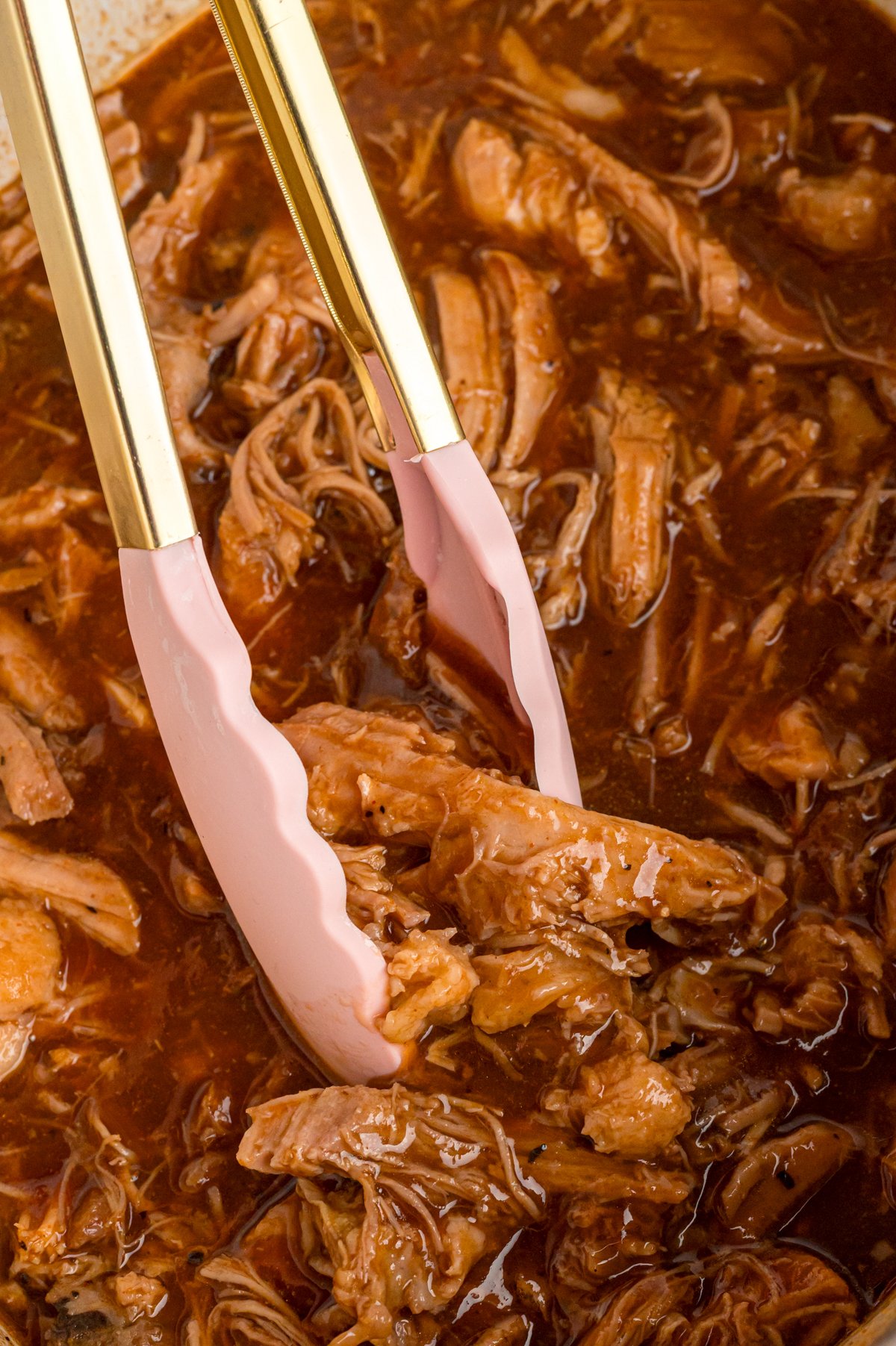 close-up of dr. pepper pulled pork in a slow cooker.