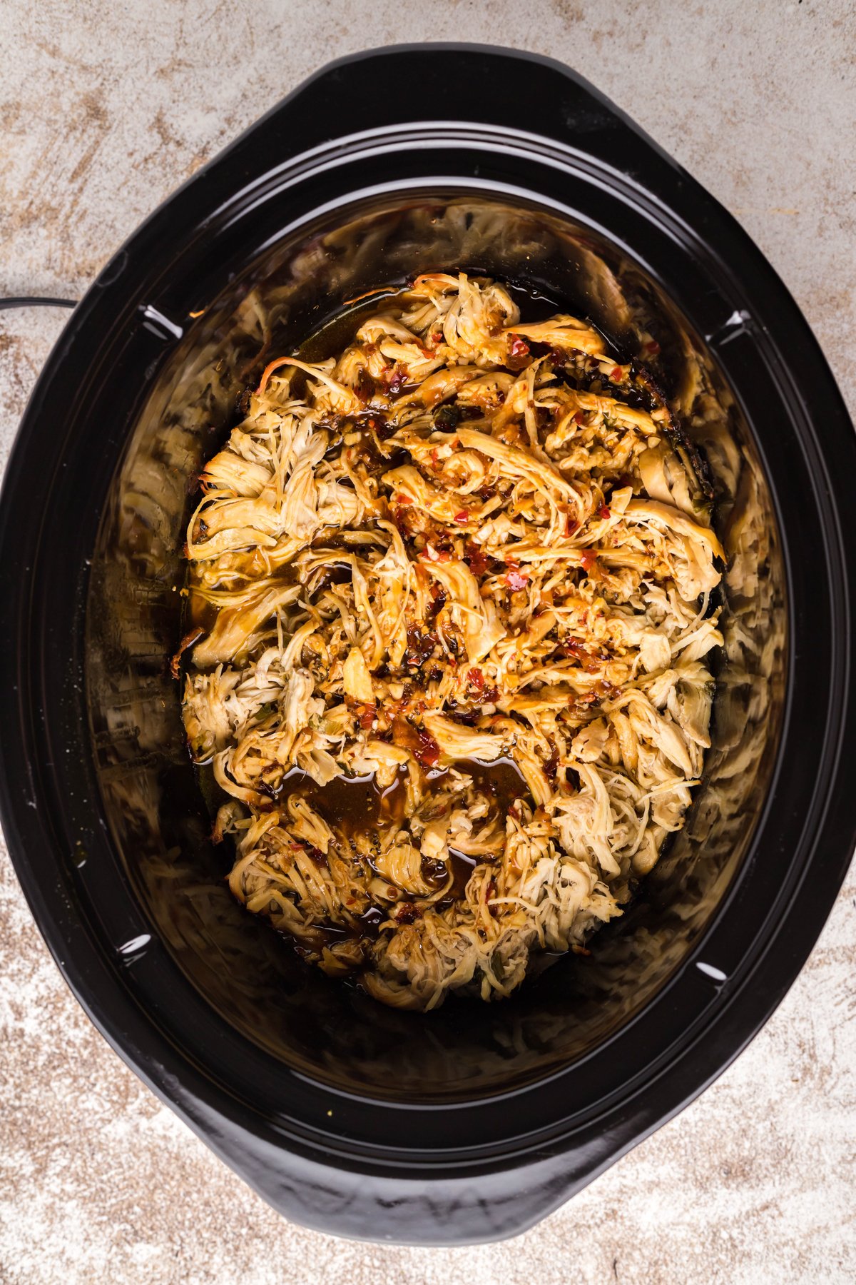 shredded chicken in the slow cooker with korean bbq sauce poured over.
