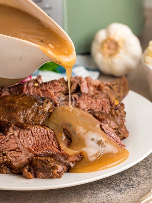 gravy being poured over sauerbraten pot roast.