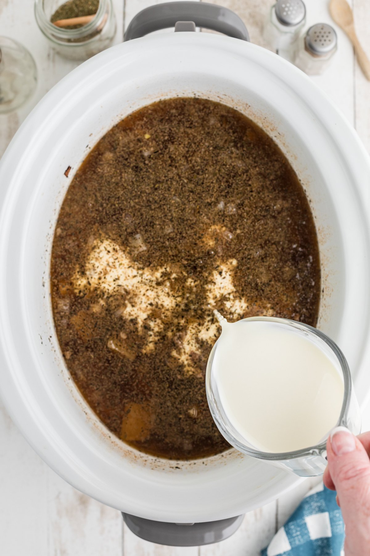 cream being added to slow cooker.