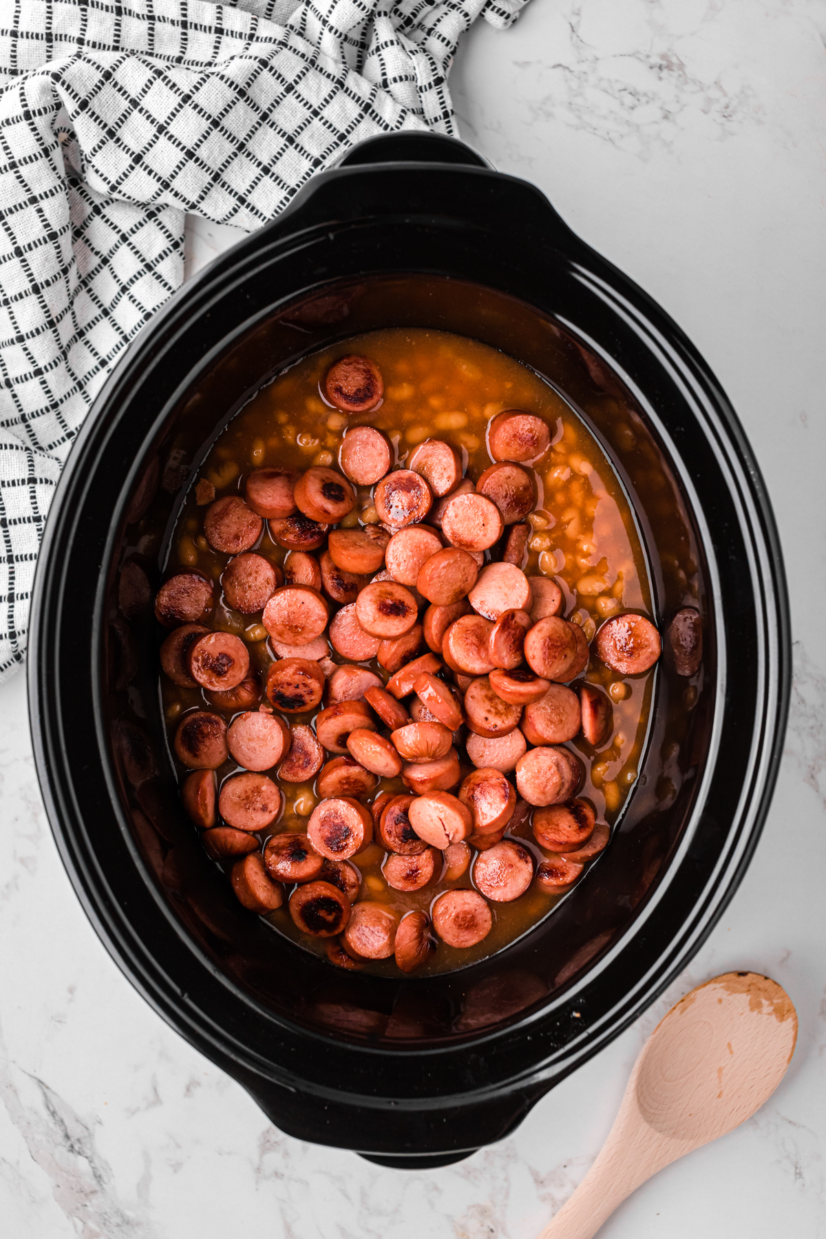 hot dogs added to the slow cooker with the beans.