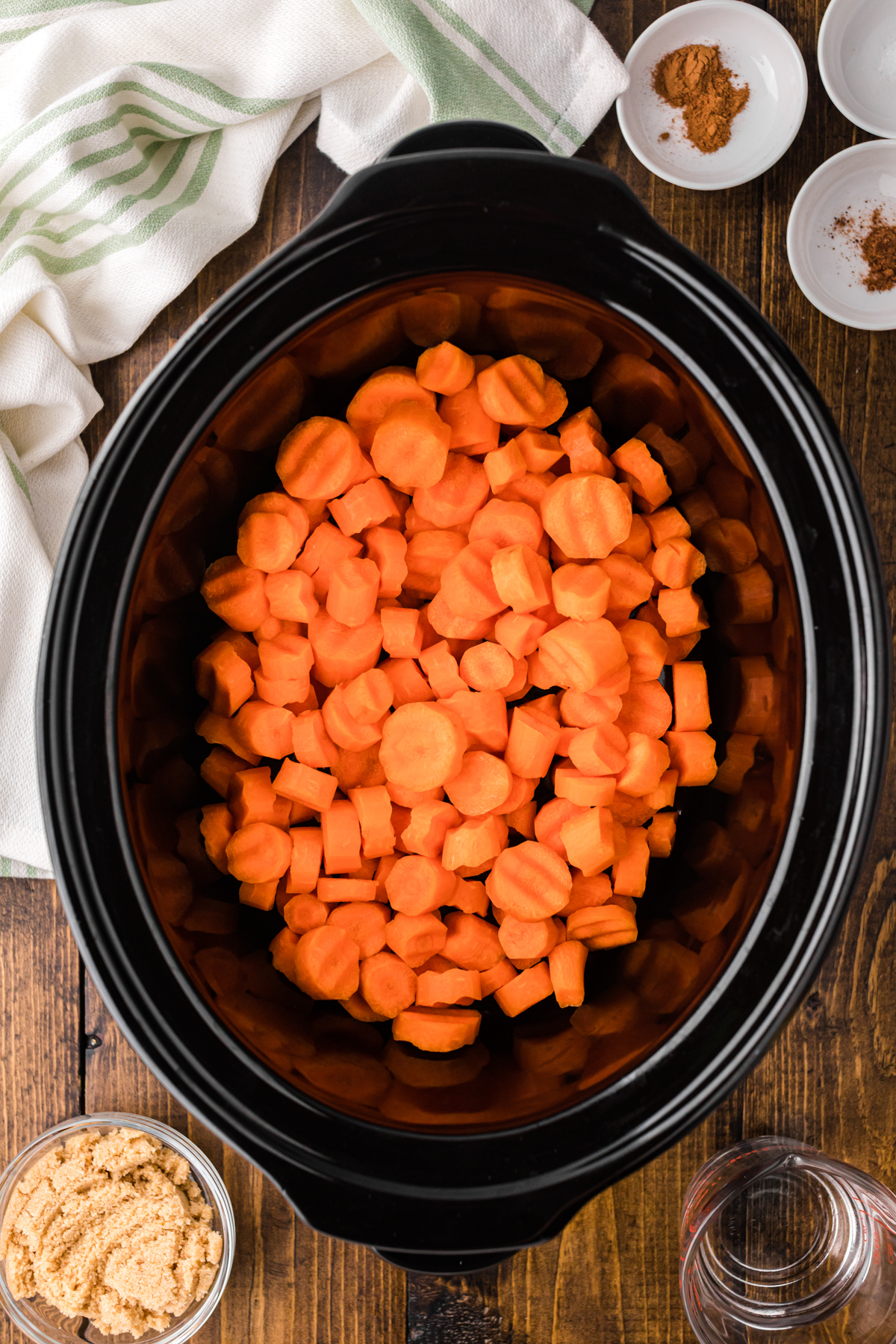 sliced carrots added to a slow cooker.