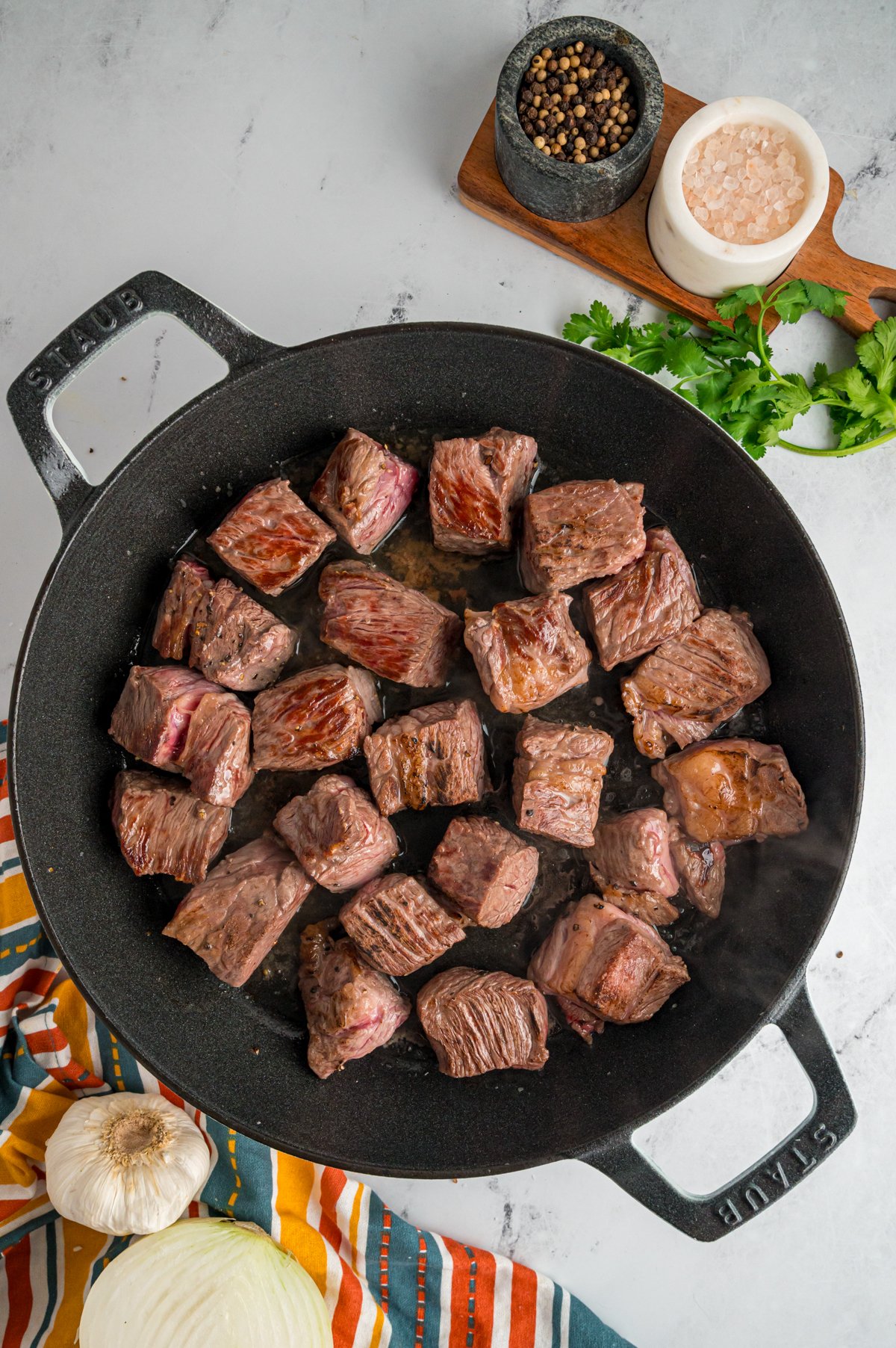 chuck roast cooking in a skillet.