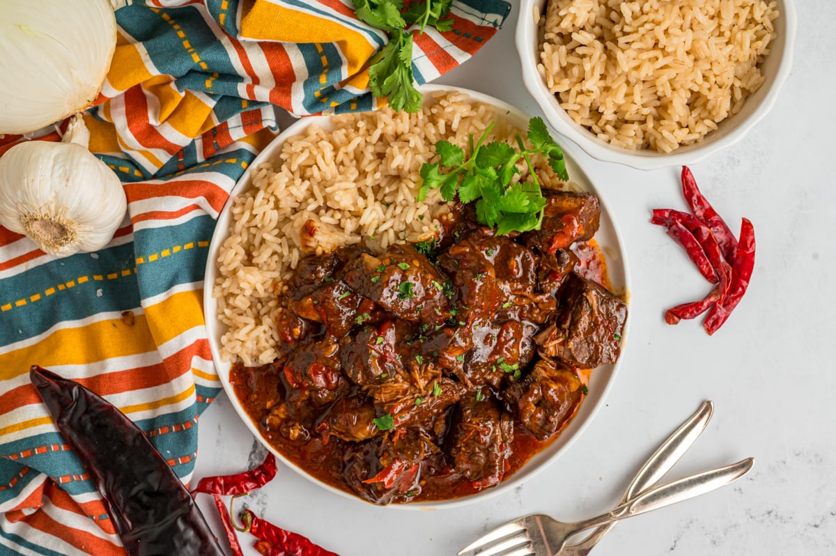 overhead of serving of slow cooker chile colorado on a plate with rice.