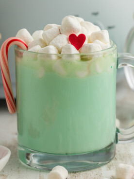 Close-up of slow cooker grinch hot chocolate in a clear mug.