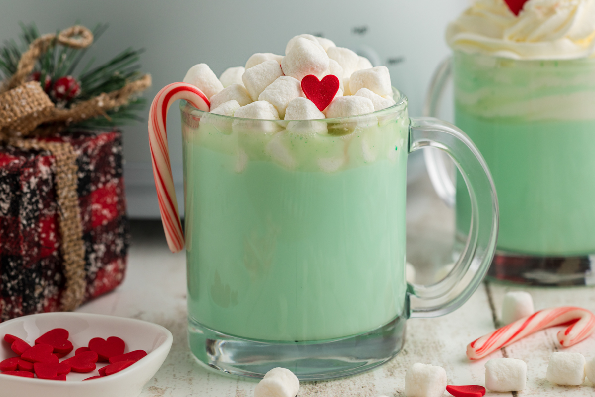 Close-up of slow cooker grinch hot chocolate in a clear mug.