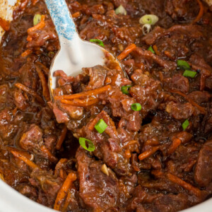 overhead of slow cooker mongolian beef with a spoon scooping some out.