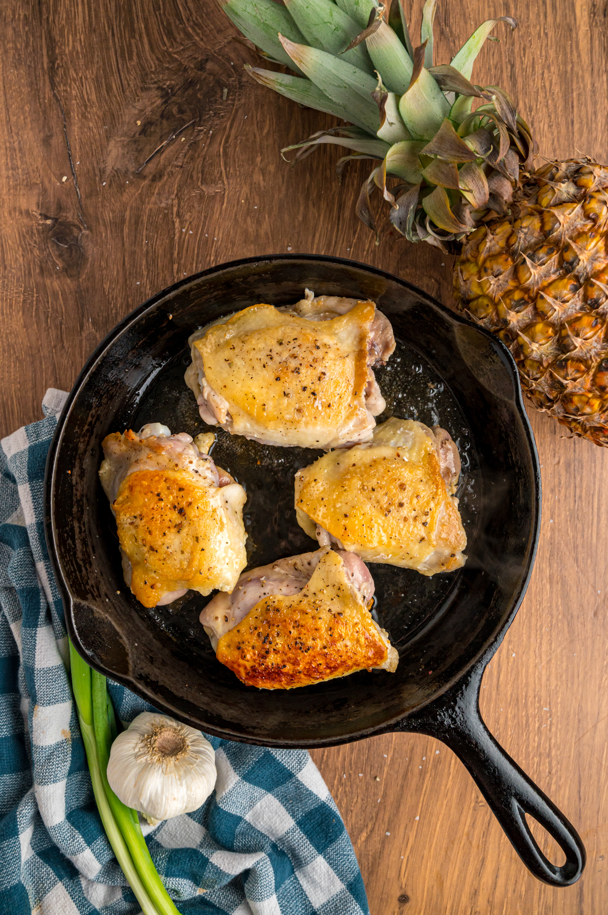 searing chicken thighs in a skillet.