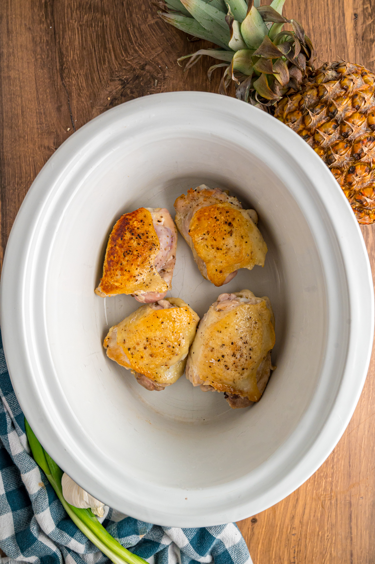 seared chicken thighs in a crockpot.