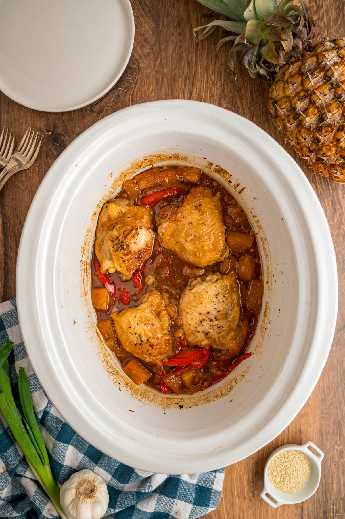 pieces of slow cooker pineapple chicken in a crockpot after cooking is complete.