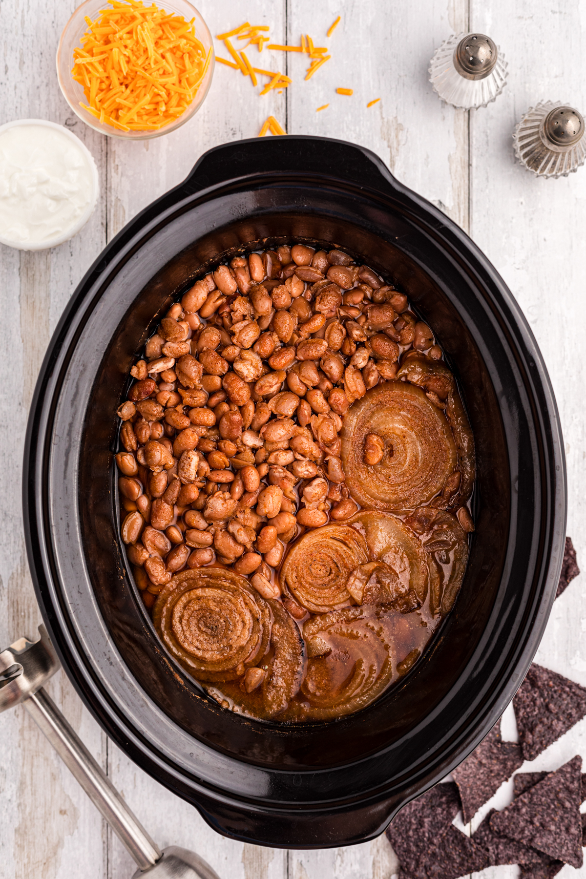 slow cooker refried beans in a crockpot after cooking but before blending.
