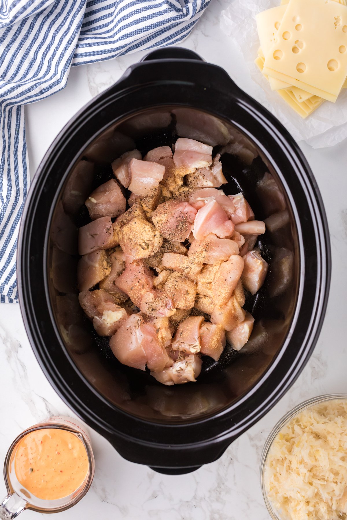 Chicken and seasonings in a crockpot.