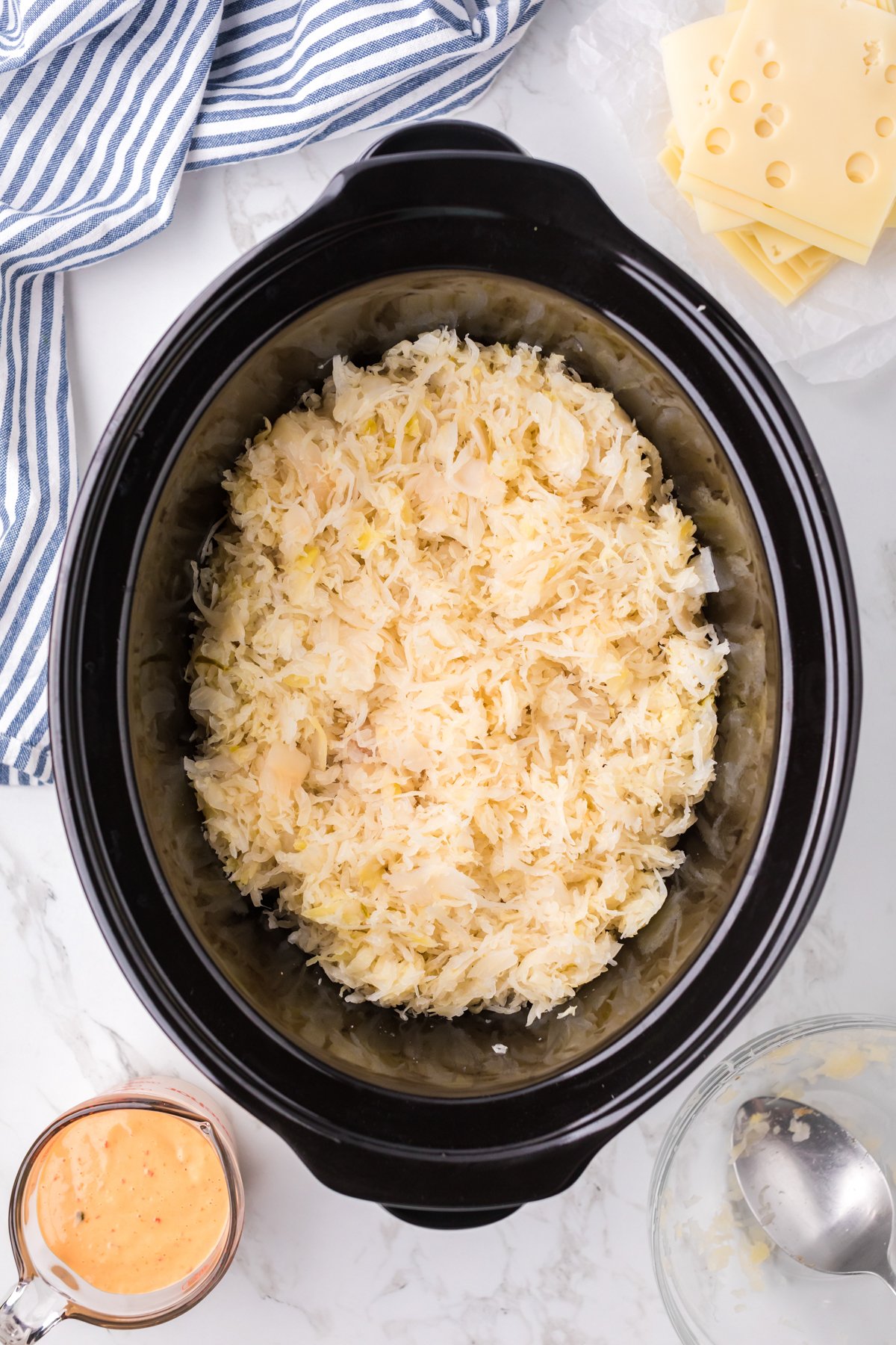 Sauerkraut added on top of chicken in a crockpot.