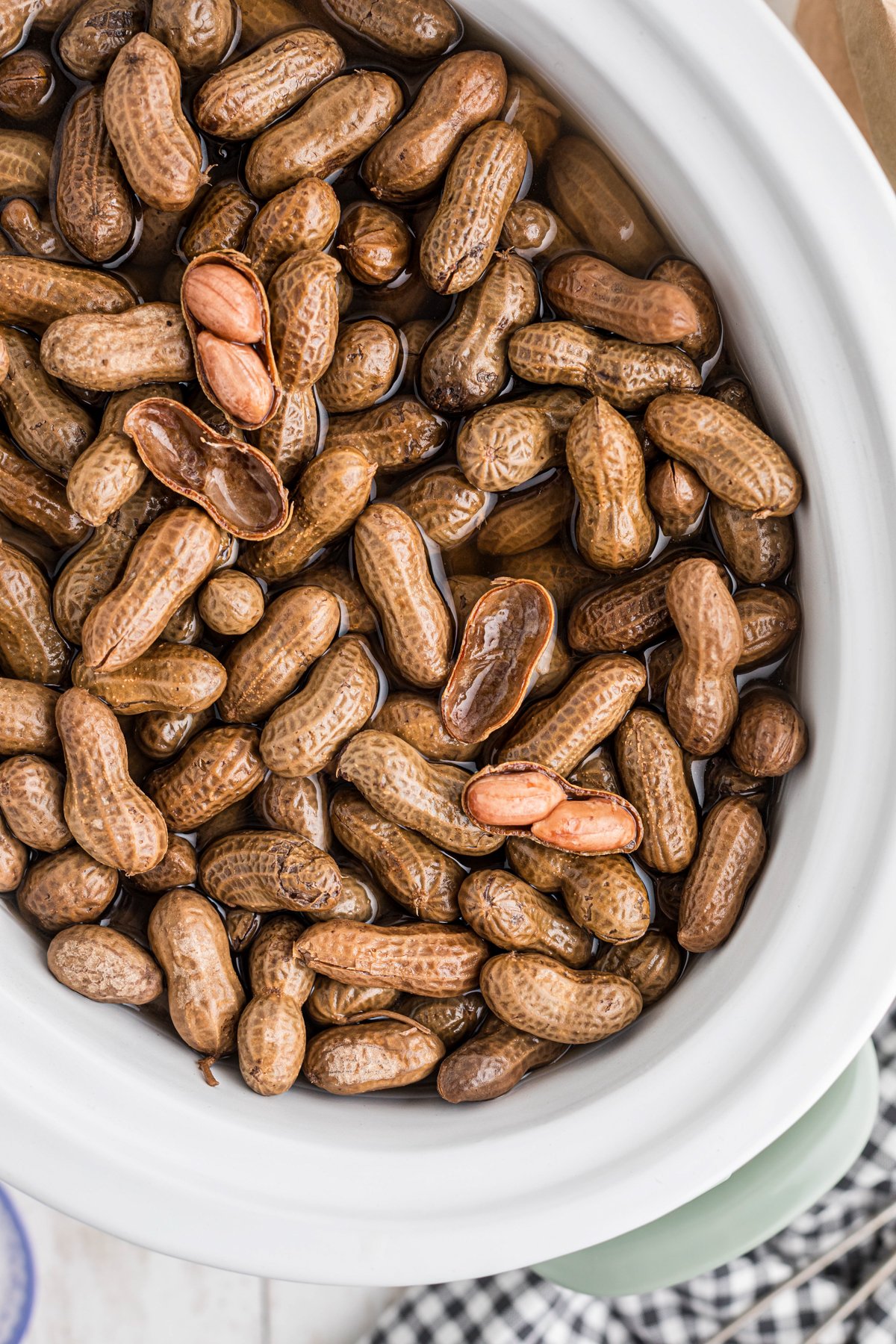 Slow cooker boiled peanuts in a white crockpot.