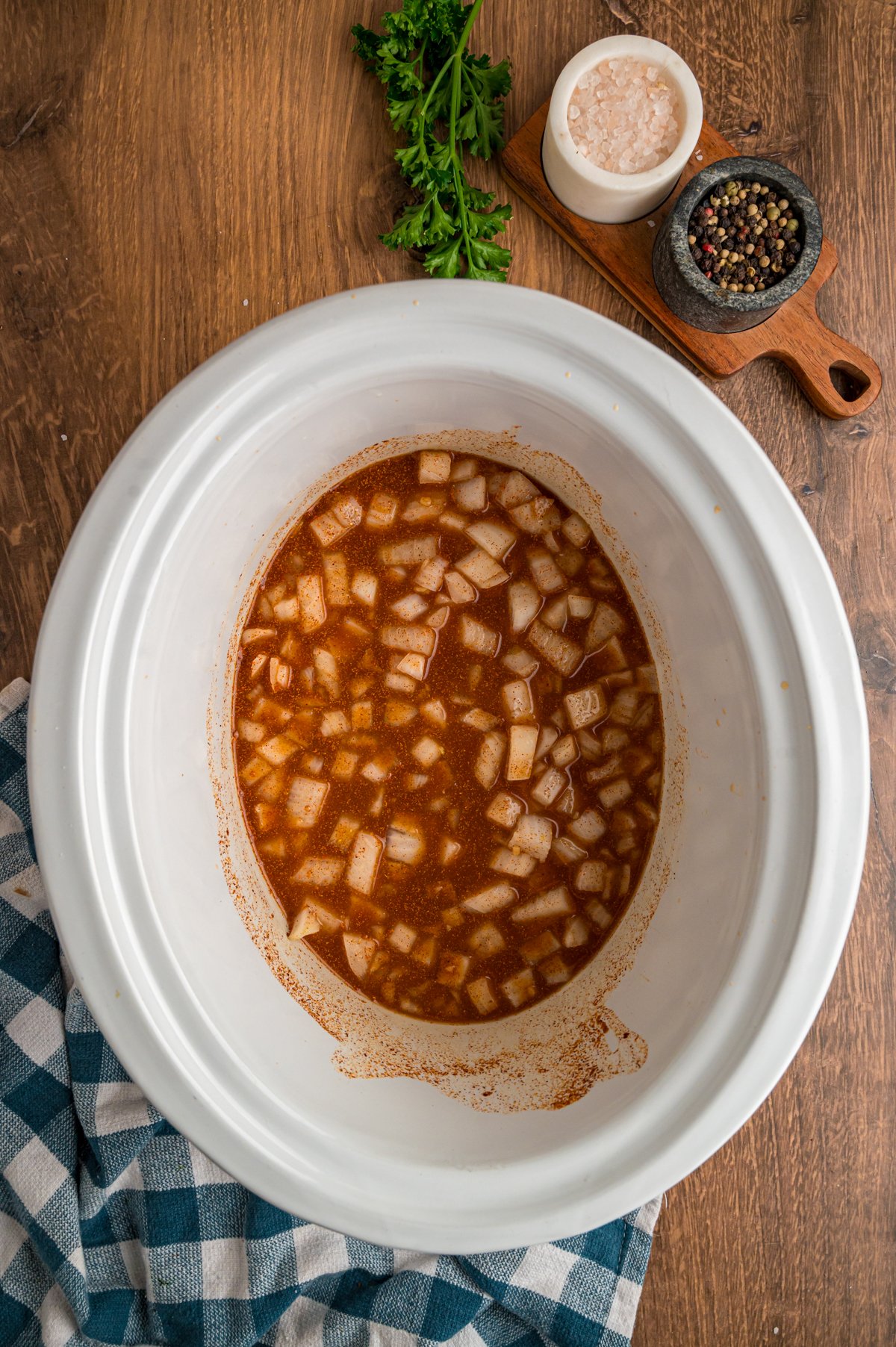 Onions, garlic, paprika, cayenne pepper, and chicken broth combined in a crockpot.