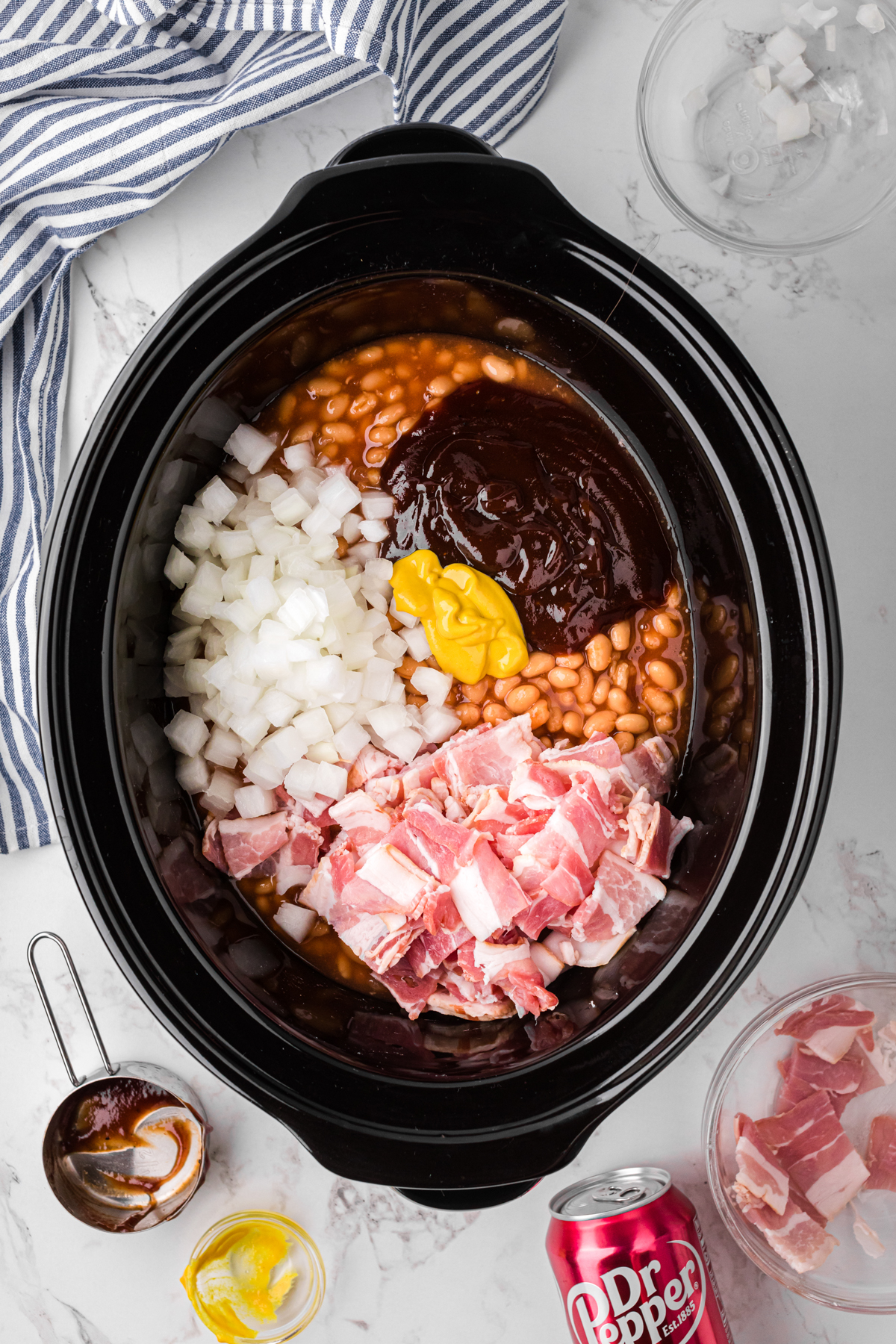 ingredients for slow cooker dr. pepper baked beans except dr. pepper in a crockpot.