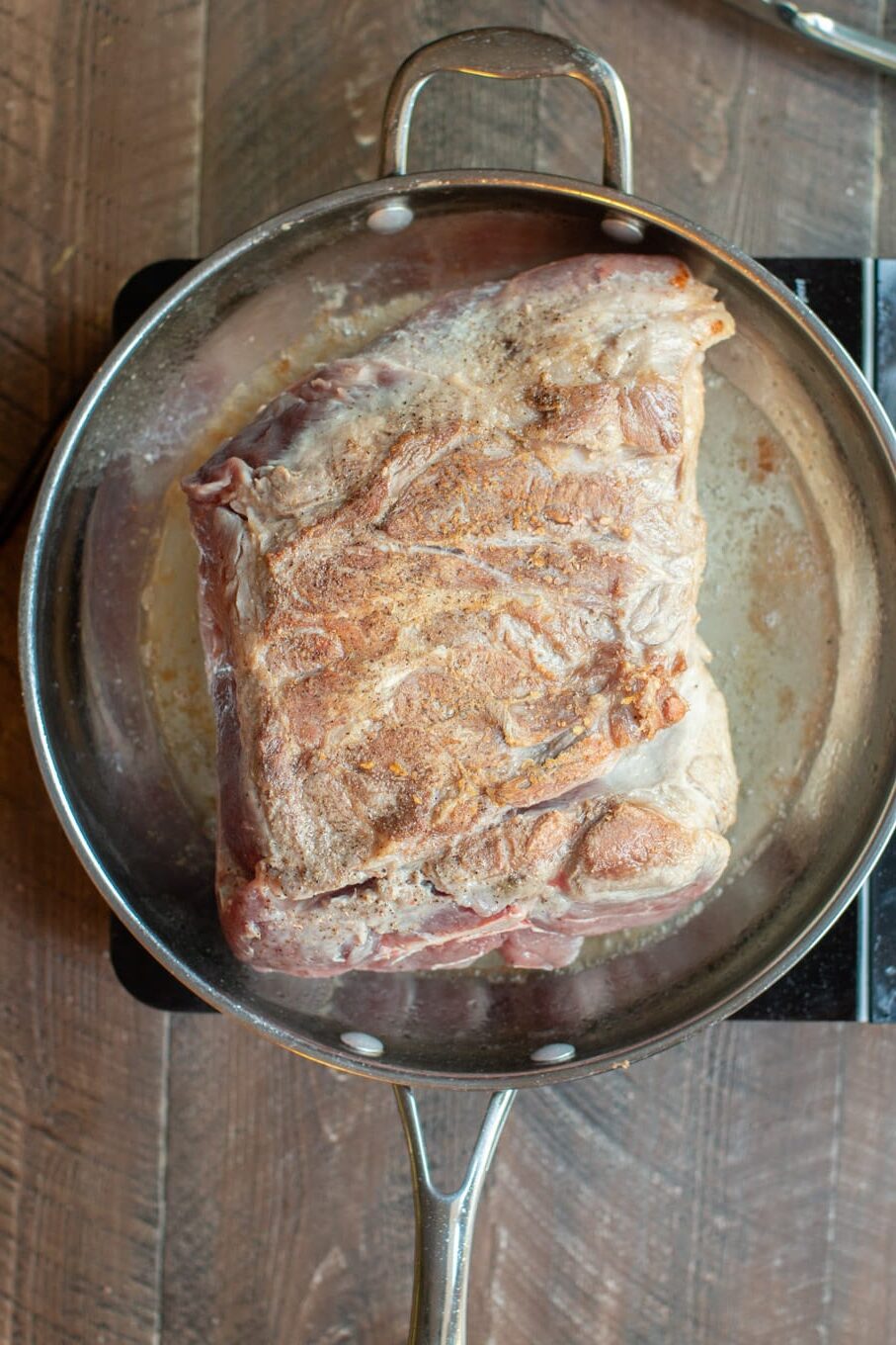 pork shoulder in a pan being browned.