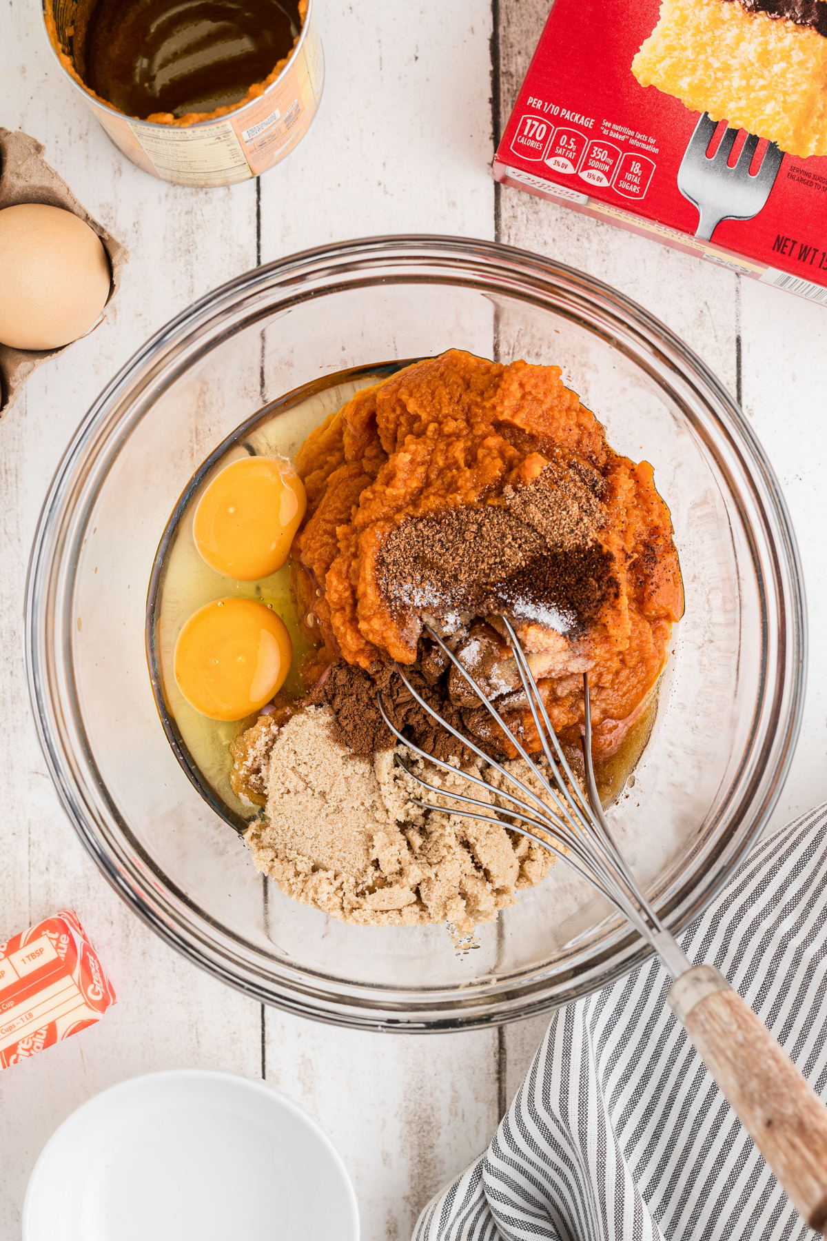 Pumpkin puree, eggs, brown sugar, cinnamon, nutmeg, cloves and salt in a bowl.