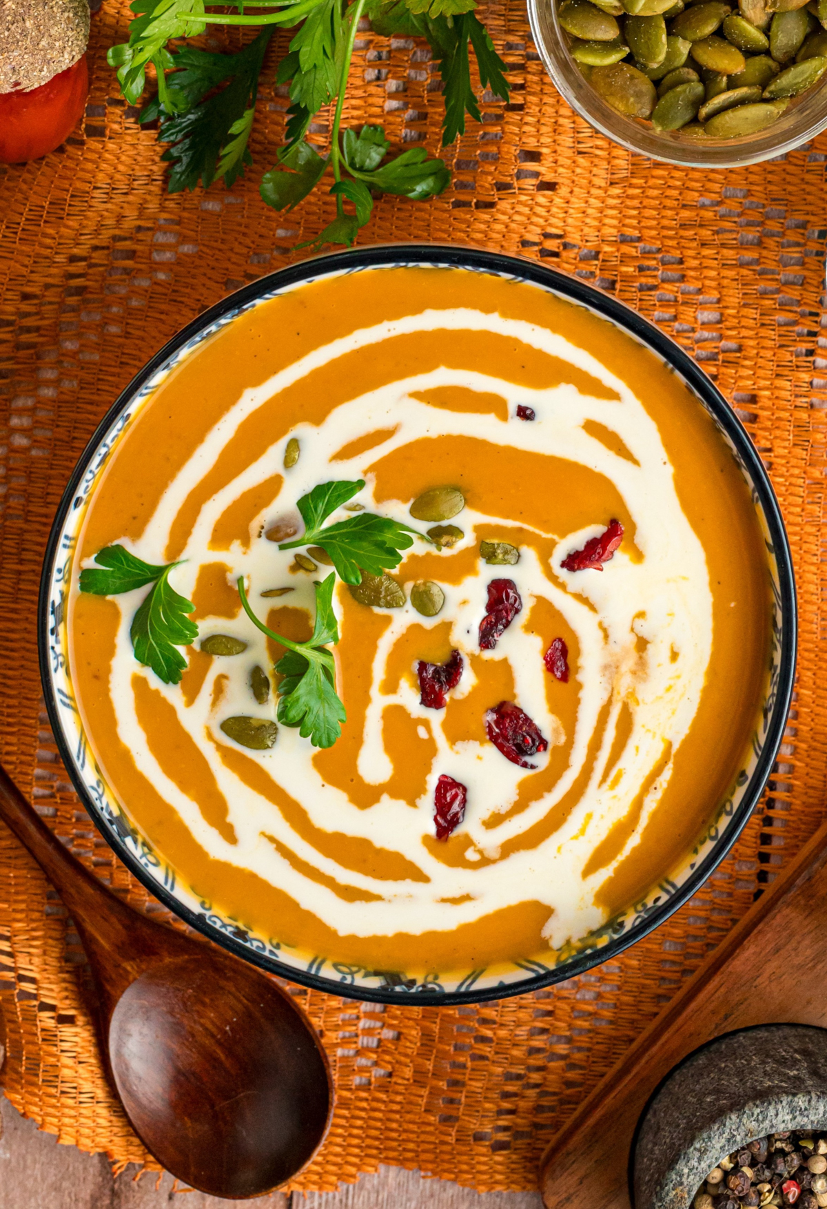 Slow cooker pumpkin soup in a bowl with a spoon next to it.