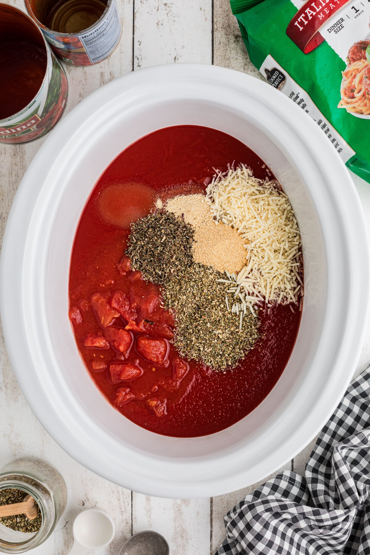 Sauce and seasonings added to a slow cooker.