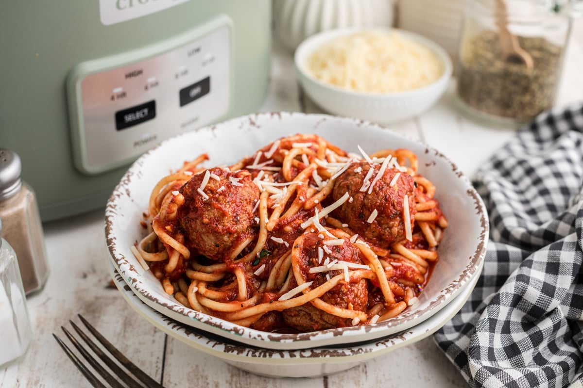 Slow cooker spaghetti and meatballs in a stack of two bowls.