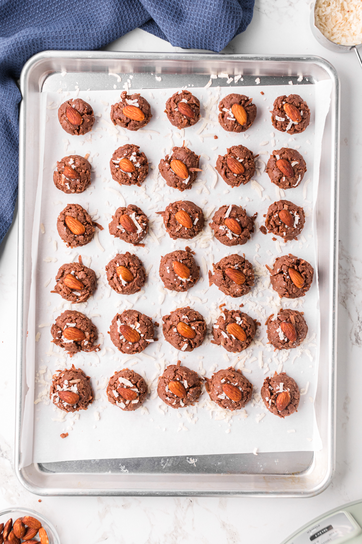 Slow cooker almond joys on a baking sheet after rolling and garnishing.