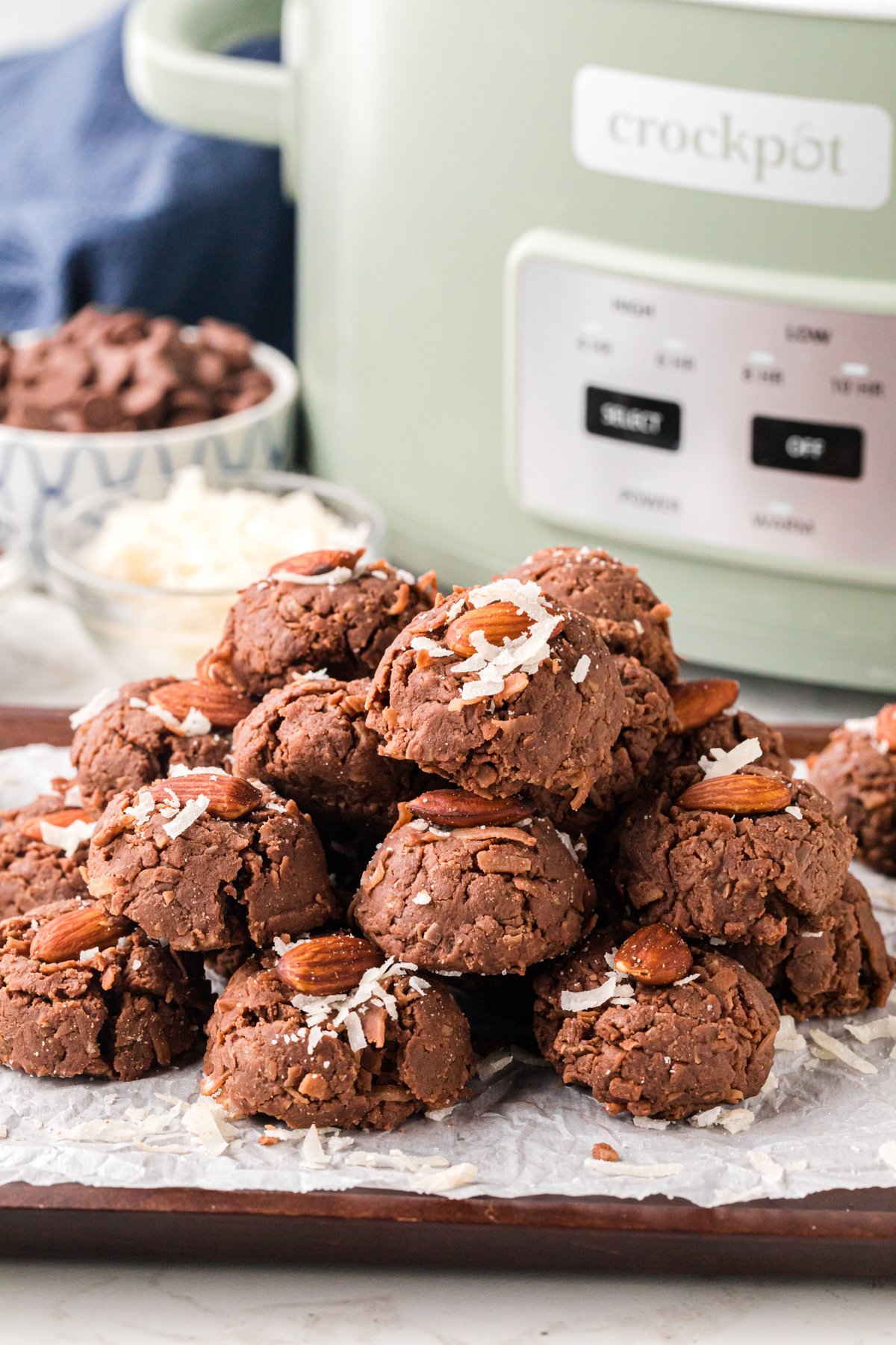 Slow cooker almond joys stacked up in front of a crockpot.