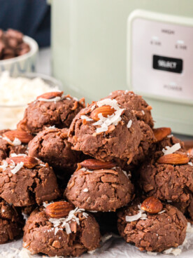 A pile of slow cooker almond joys in front of a crockpot.