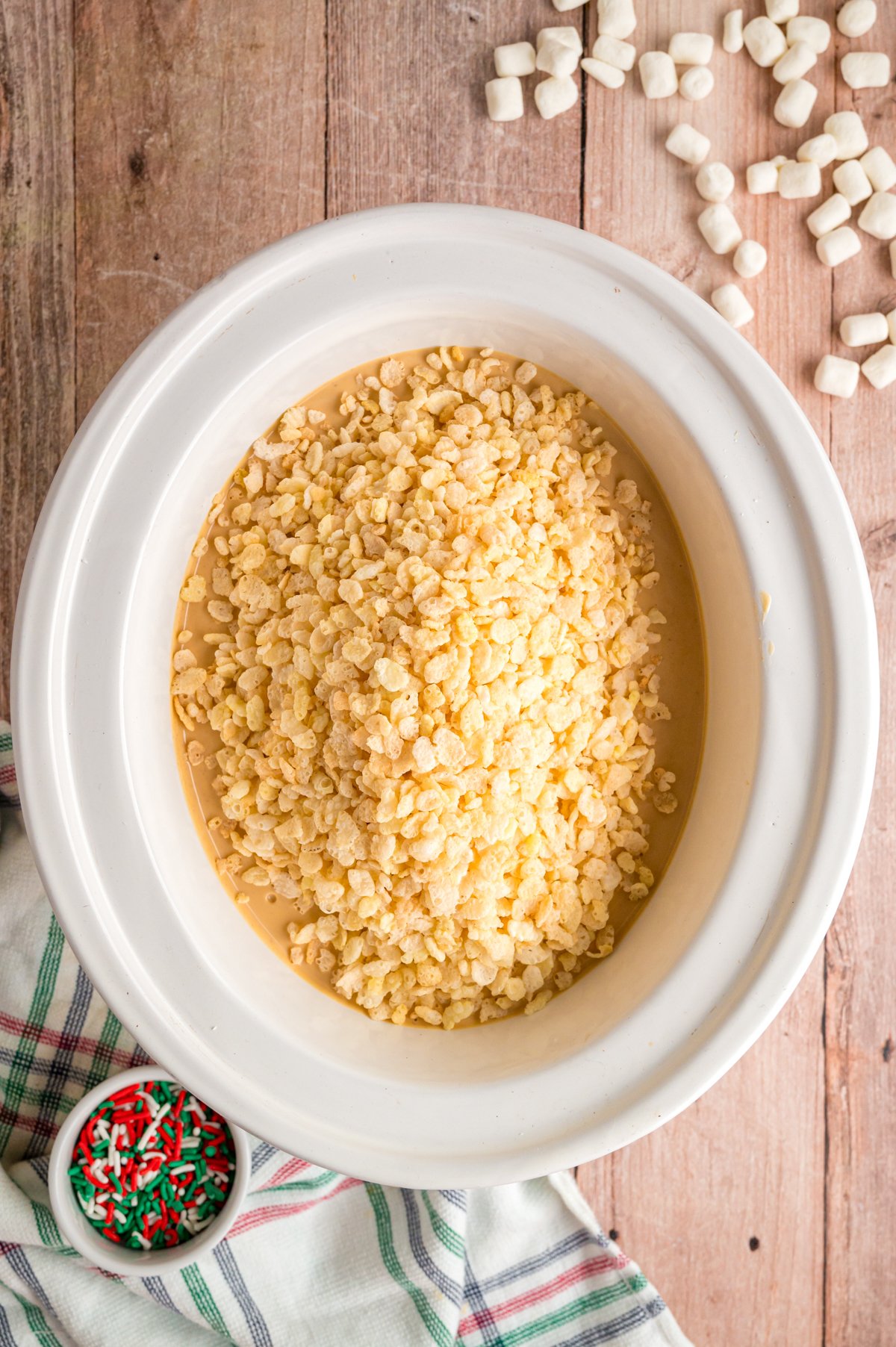 Crispy rice cereal added to melted almond bark and peanut butter in a crockpot.