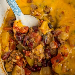 A spoon taking a scoop of slow cooker cowboy casserole.