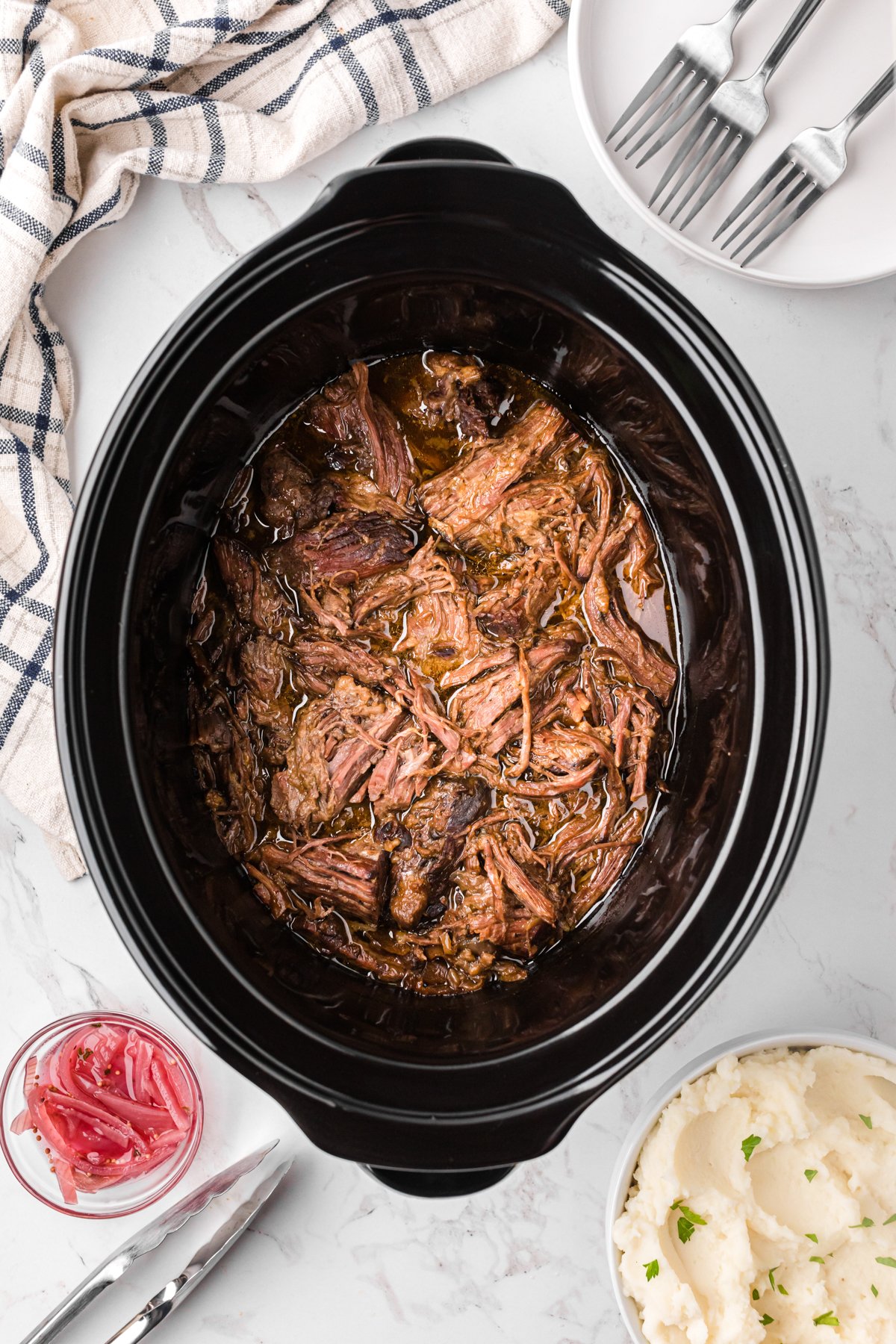 Georgia pot roast in a slow cooker after the meat has been shredded.