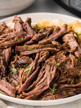 A close-up of a serving of slow cooker pot roast on a plate.