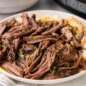 A close-up of a serving of slow cooker pot roast on a plate.
