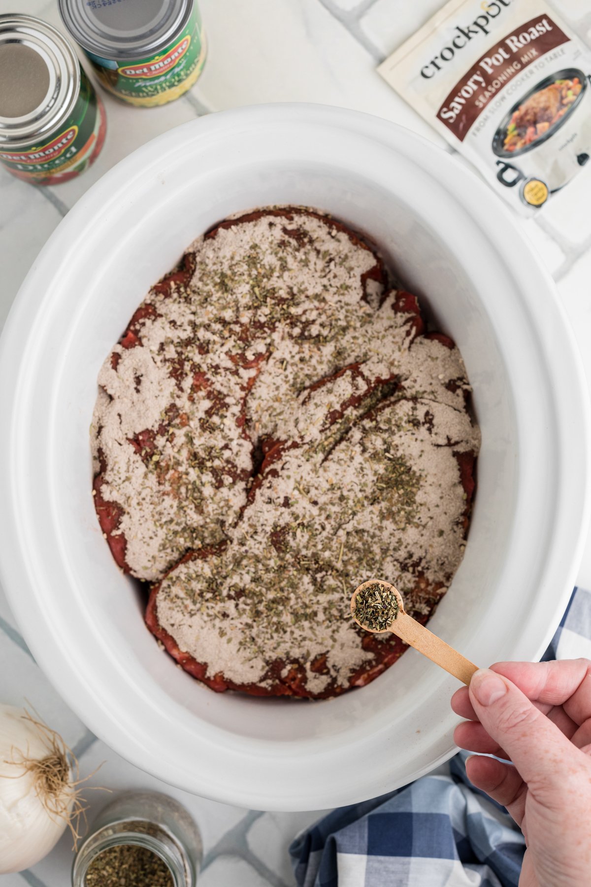 Chuck roast and seasonings in a crockpot.