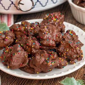 Slow cooker turtles with sprinkles on a plate.