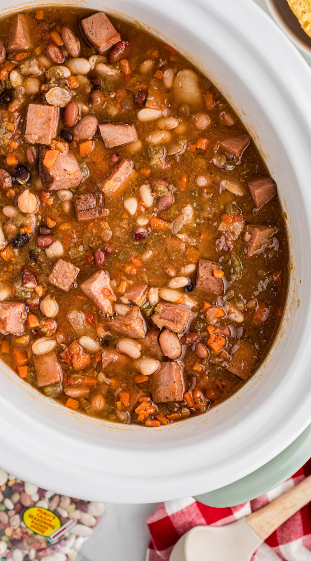 Long image of slow cooker smoked turkey cajun 15 bean soup.