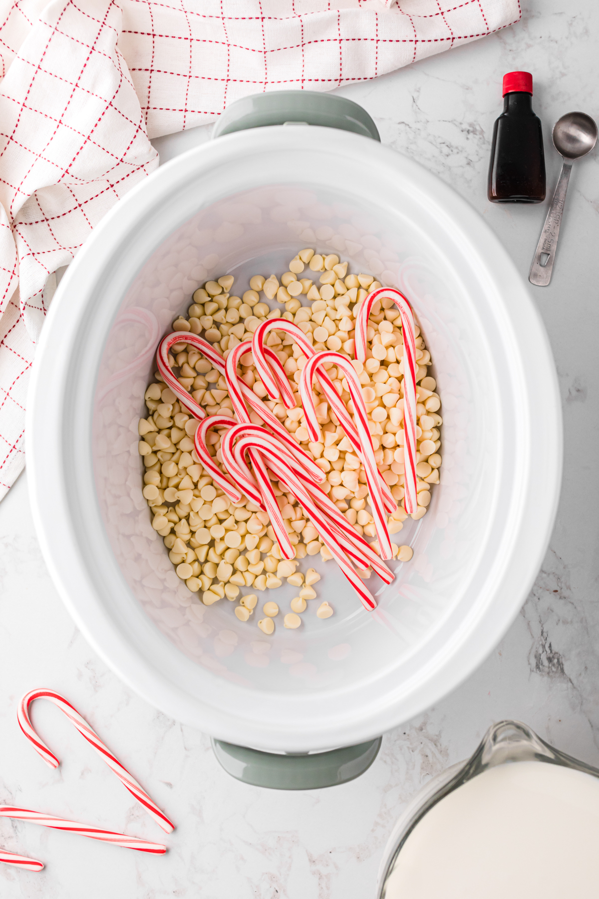 Candy canes and white chocolate chips in a crockpot.
