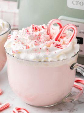 slow cooker candy cane hot chocolate in front of a crockpot.