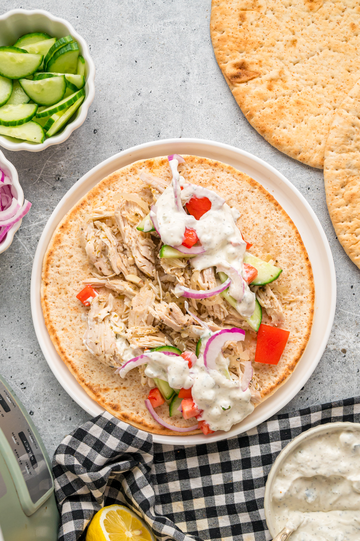 Shredded chicken and toppings added to a pita to make a gyro.