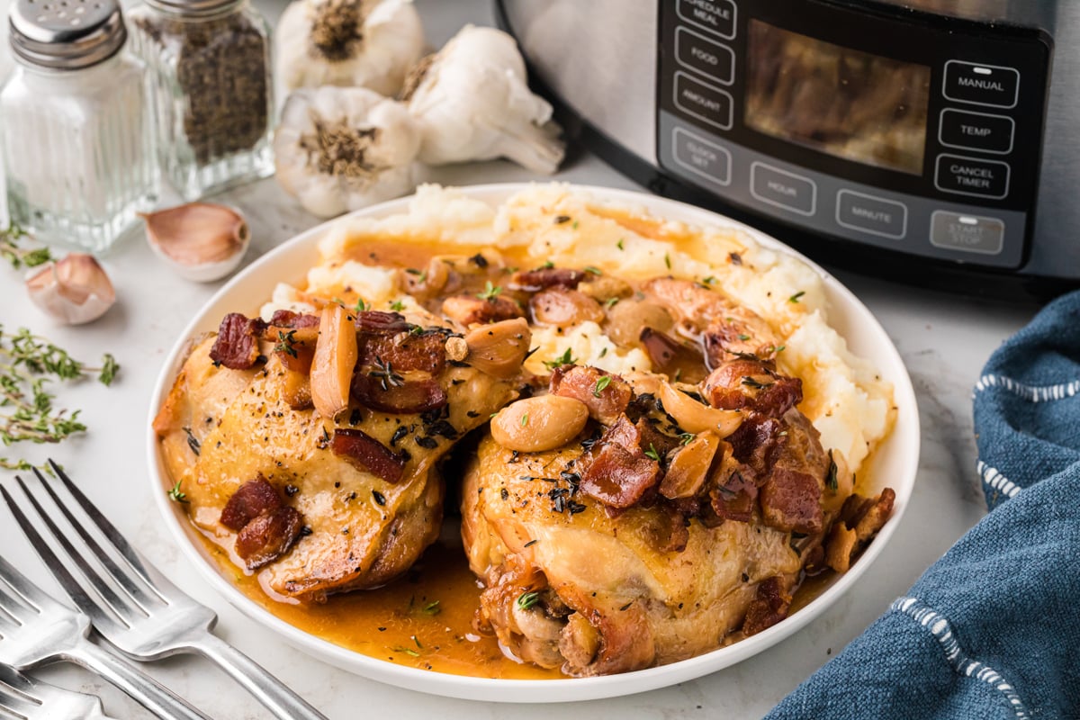 A serving of slow cooker 40 clove chicken in a white bowl.