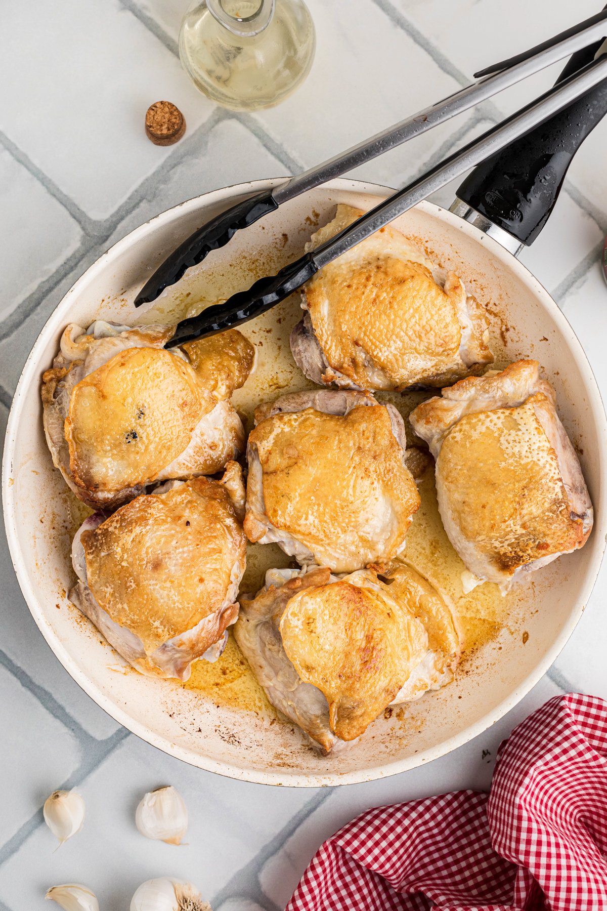 Searing chicken thighs in a skillet.