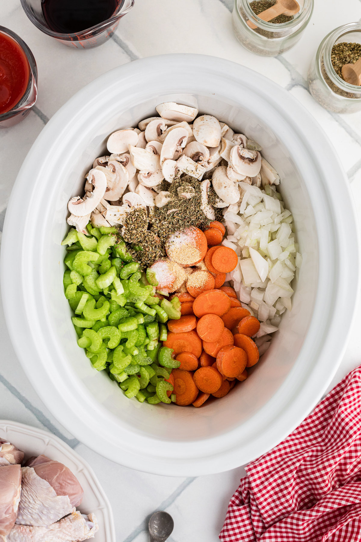 Veggies and seasonings in a slow cooker.