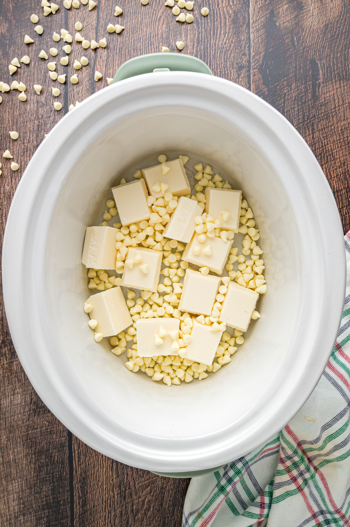 Vanilla almond bark and white chocolate chips in a crockpot.