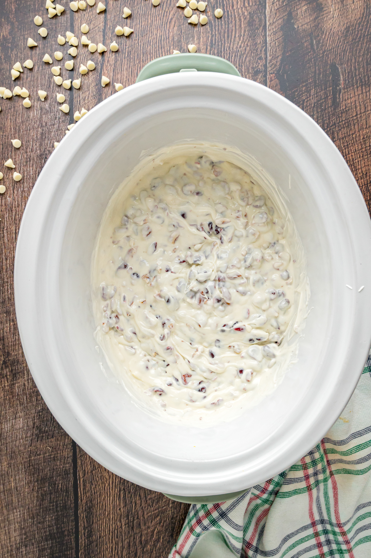 Mixture for white chocolate cranberry clusters in a crockpot.